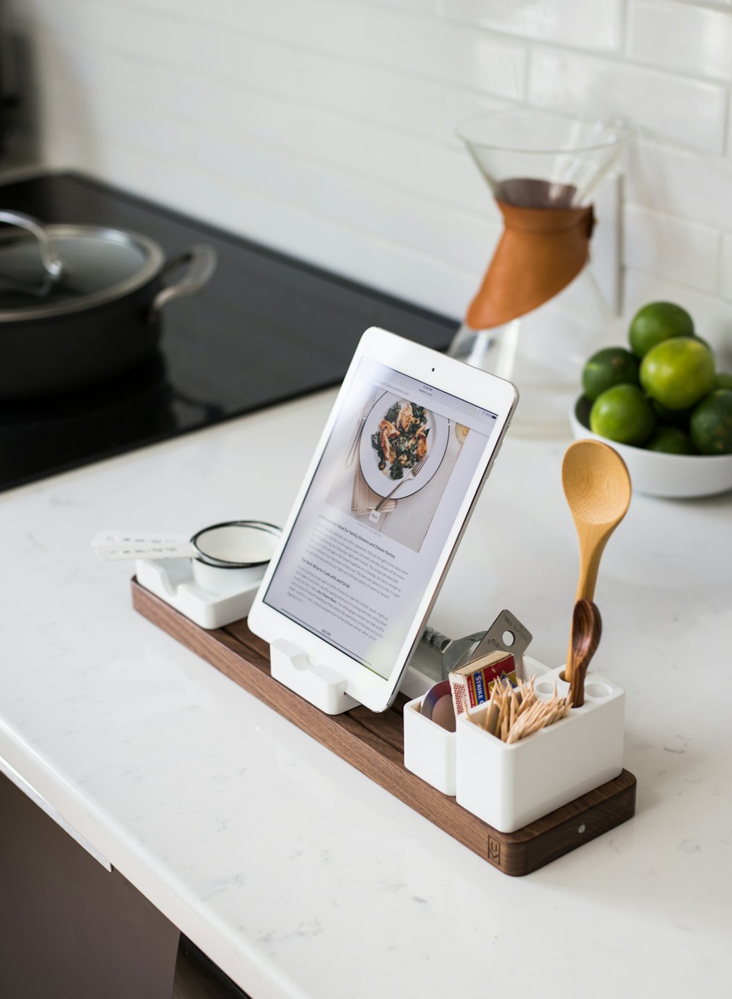 Küchenarbeitsplatte mit iPad-Rezept, Kaffeemaschine und Limetten.
